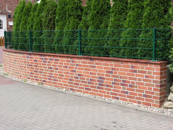 Klinkermauer mit Doppelstabzaun vor einer Thujahecke