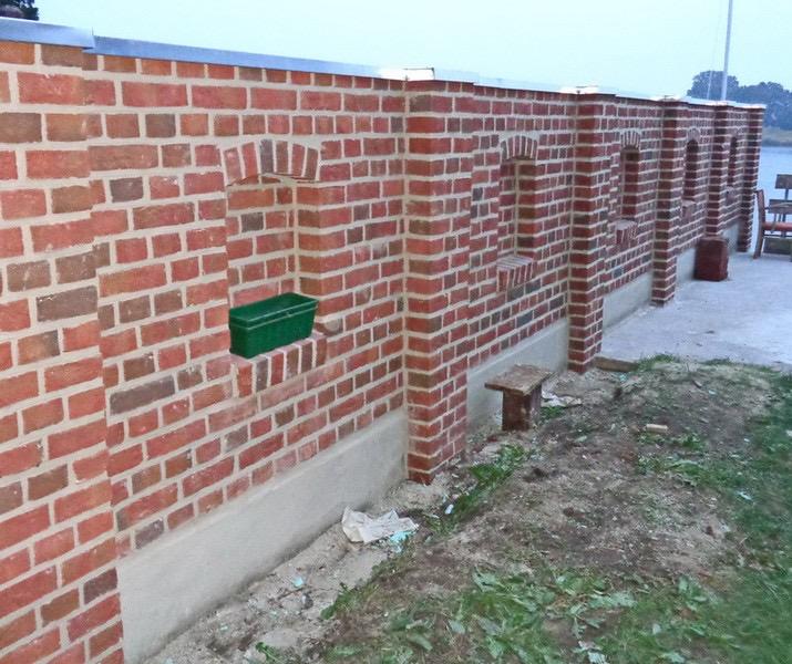 Klinkermauer mit Ziermuster und Betonsockel am Wasser