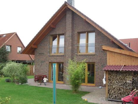 Einfamilienhaus in Klinker mit Balkon und Holzelementen am Giebel