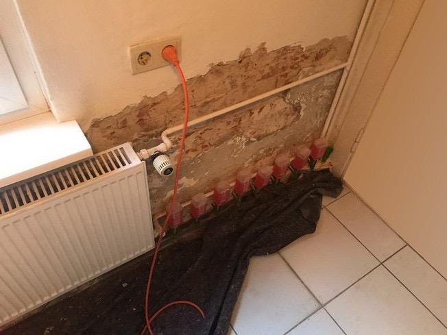 Abgeschlagener Sockelputz mit gesetzten Injektionsflaschen an der Wand