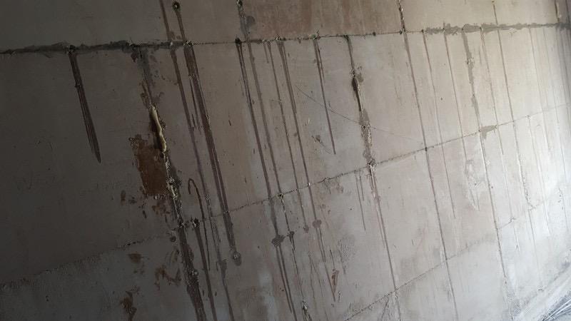 Kalksandsteinwand mit einer Reihe gesetzter Injektionsstellen