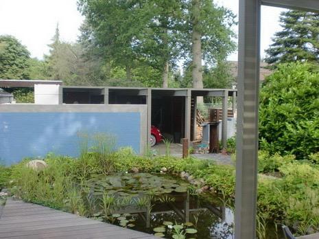 Gartenseite mit Sichtwand, Teich und Carport nach dem Umbau